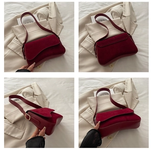 Detail view of burgundy faux leather and suede shoulder bag with magnetic flap and metal buckle