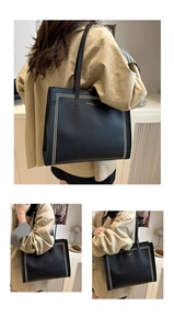 Détail d'un sac cabas en cuir grainé noir avec des bordures de rivets dorés verticaux