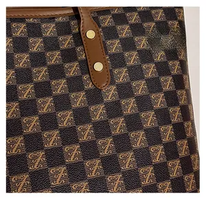 Macro detail of checkered tote bag fabric with leather strap and gold metal rivets