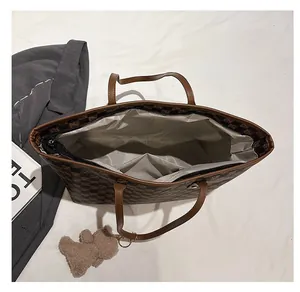 Top view of brown checkered tote bag interior with zipper and bear plush pendant