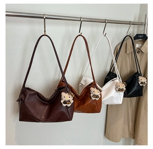 Row of four colorful faux leather tote bags hanging with cute plush kitty charms