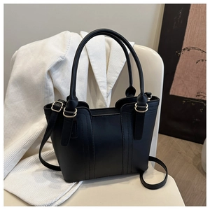 Detailed close-up of a black matte PU leather bucket bag with vertical stitching and gold hardware