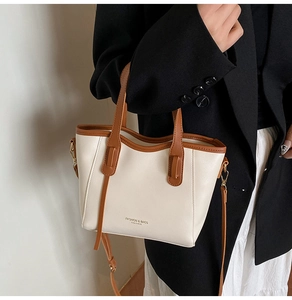Detail of contrast stitch tote bag featuring leather handles and detachable shoulder strap