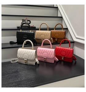Detailed display of six colorful quilted handbags with gold hardware on tiered display