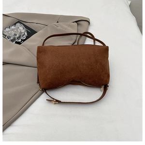 Details der braunen Wildledertasche mit Vintage-Design und goldenen Metallteilen
