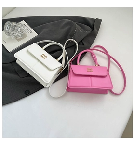 Detailed close-up of textured leather mini square bags in white and pink with logo