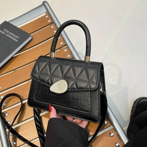 Sac à main noir matelassé minimaliste avec texture crocodile et fermoir doré chic