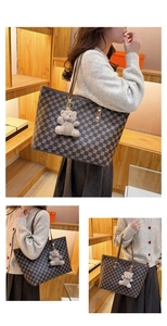 Detail of a large checkerboard tote bag with slim brown leather straps and plush charm