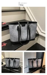 Close-up of contrast stitching felt tote bag with leather straps and fashion label