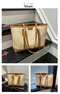 Detail of khaki canvas tote bag with brown leather trim and color-blocking design
