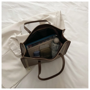 Intérieur spacieux d'un sac cabas en cuir marron foncé avec accessoires quotidiens