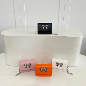 Minimalist crossbody flap bags in black, pink, orange, and white with silver bow clasps