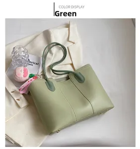 Detail of light green tote bag with leather texture and cute pink peach charm