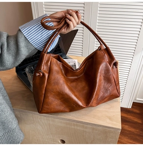 Detailed macro view of brown faux leather texture and embossed brand logo on tote bag