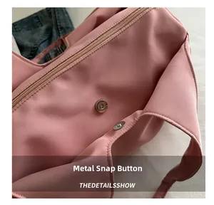 Close-up of metal magnetic snap closure and zipper on a pink pleated shoulder bag