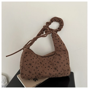 Détail du sac en velours côtelé marron avec motifs cœurs, nœuds et bandoulière plissée