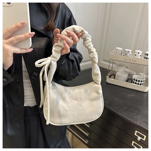 Detail of corduroy bag handle with ruffle pleats and pink bow embroidery accent