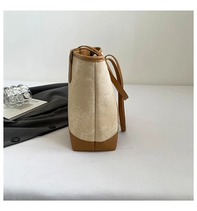 Side view of beige canvas tote bag with brown leather trim for daily commute