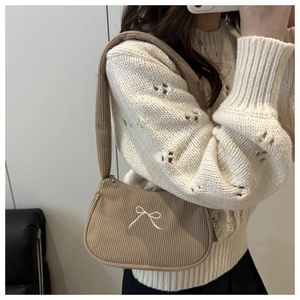 Detailed texture of khaki corduroy hobo bag with delicate white butterfly embroidery