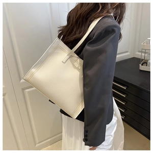 Détail du cabas en cuir grainé crème montrant les doubles coutures et la bandoulière