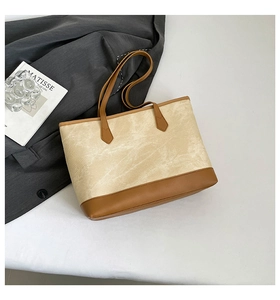 Close-up of retro beige tote bag with textured faux leather and brown handles for work