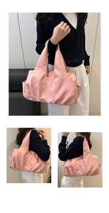 Detail of a large pink ruched canvas tote bag worn as a shoulder bag for daily commute