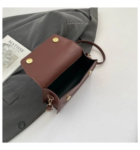 Interior view of brown leather crossbody bag with golden hardware and flap closure