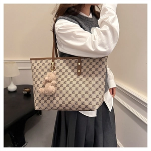 Close-up of checkerboard tote bag with Z pattern and cute beige teddy bear charm