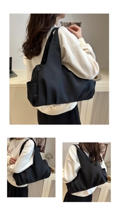 Detail view of large black pleated shoulder bag showing spacious side pockets and nylon texture