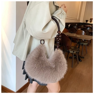 Plush crescent bag with beaded handle detail worn in a cozy cafe setting
