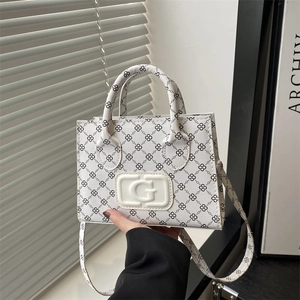 Chic white crossbody bag with black G monogram pattern and adjustable shoulder strap