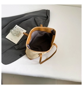Spacious tote bag interior view with canvas fabric and brown leather handle detail
