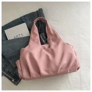 Detail of pink pleated tote bag with smooth glossy fabric and spacious interior