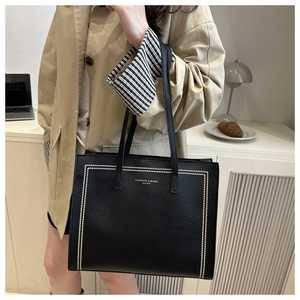 Détail du cabas en cuir grainé noir avec lettrage doré pour le travail