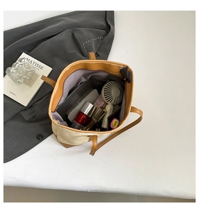 Detail view of large canvas tote bag interior with multiple everyday items stored inside