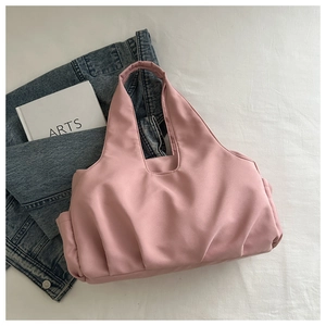 Detailed top view of light pink pleated tote bag with side pockets and smooth fabric