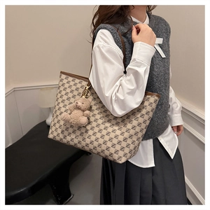 French style tote bag with geometric pattern and teddy bear charm on shoulder