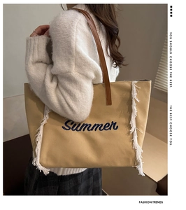 Détail du cabas en toile beige avec broderie 'Summer' et franges latérales blanches