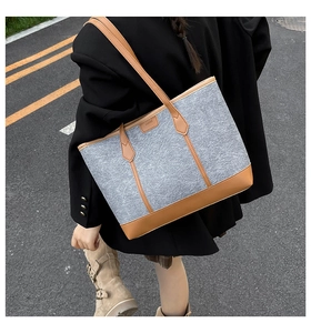 Detail showing grey felt tote bag with brown leather trim and long shoulder straps