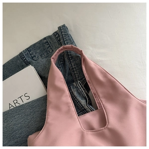 Close-up of pink pleated shoulder bag showing wide strap detail and nylon fabric texture