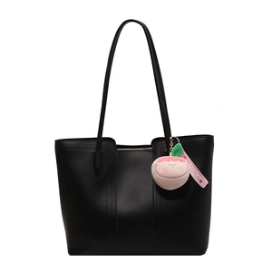 Minimalist black tote bag with vertical stitching and cute pink peach plush charm