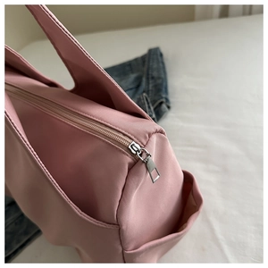 Detailed macro shot of pink pleated tote bag showing nylon texture and silver zipper