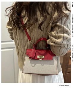 Detail of red pebbled leather and beige canvas textures on a stylish crossbody Kelly bag