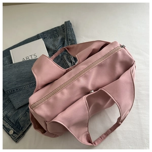 Detailed close-up of pink oversized shoulder bag with wide strap and side pockets