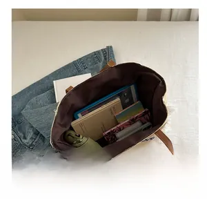 Vue intérieure montrant la grande capacité du sac fourre-tout en toile beige à lanière