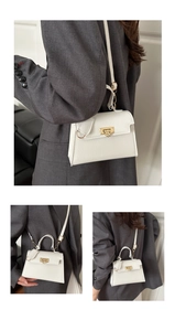 Details der weißen Lederhandtasche mit Litschi-Muster und goldenem Verschluss