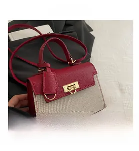 Detail view of red leather and canvas patchwork bag with gold metal buckle