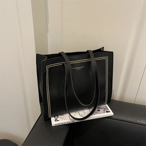Sac cabas en cuir grainé noir avec rivets dorés et longues anses pour le quotidien