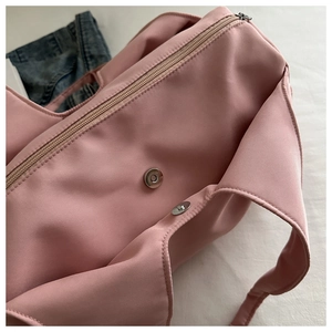 Detail of pink pleated shoulder bag with smooth zipper and high-density waterproof nylon fabric