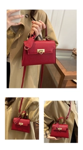 Rote Handtasche mit Lederstruktur und Goldschloss als Hand- und Umhängetasche gezeigt
